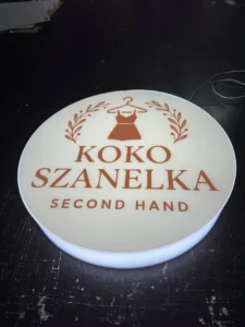 Okrągły kaseton z plexi z logo KOKO SZANELKA Second Hand, podświetlenie LED, druk UV