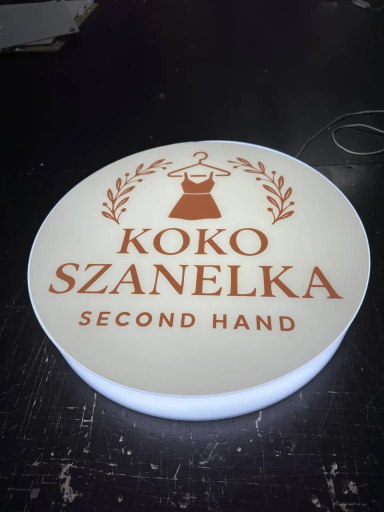 Okrągły kaseton z plexi z logo KOKO SZANELKA Second Hand, podświetlenie LED, druk UV