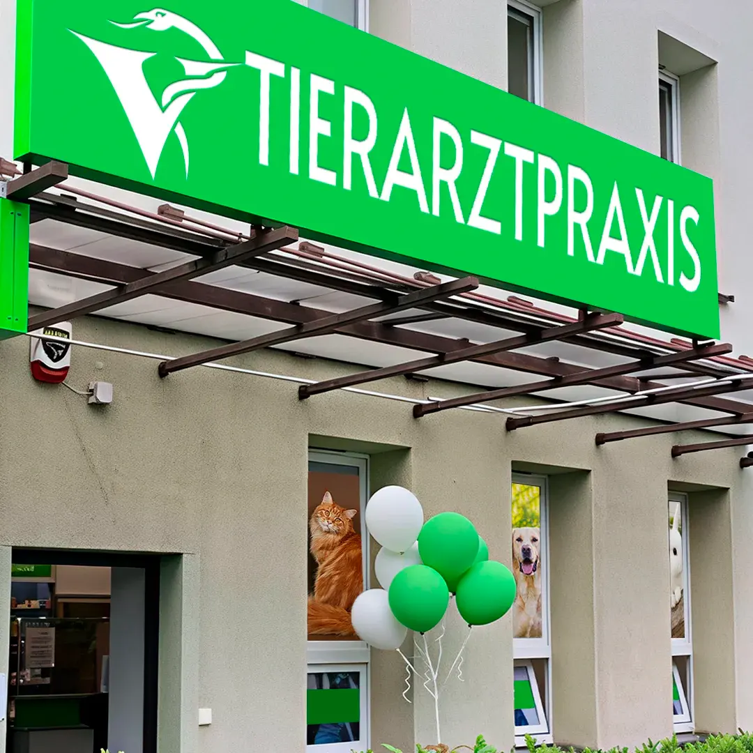 Gruenes Werbeschild fuer Tierarztpraxis an der Fassade