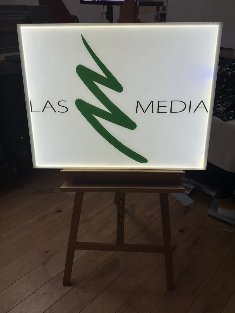 Beleuchtetes Firmenschild fuer Medienunternehmen mit gruenem Logo