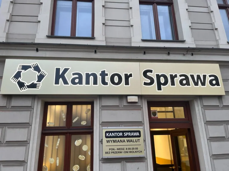 Beleuchtetes Firmenschild der Wechselstube Kantor Sprawa an einer Gebaeudefassade