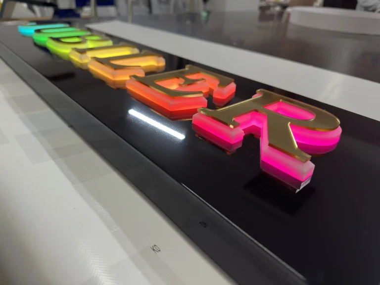 Farbige 3D-Buchstaben auf schwarzem Dibond-Leuchtkasten