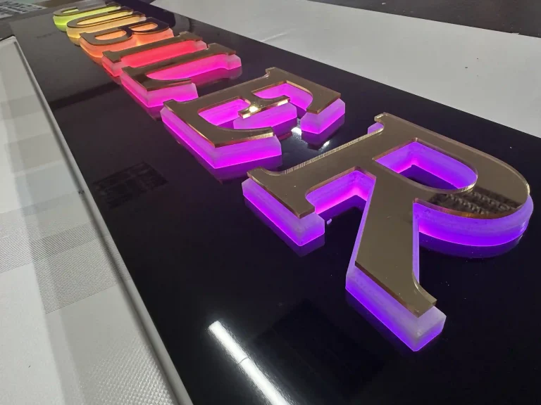 Goldene 3D-Buchstaben mit LED-Beleuchtung auf Dibond