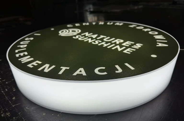 Detailansicht eines runden Leuchtkastens mit beleuchtetem floralem Design auf dunklem Grund
