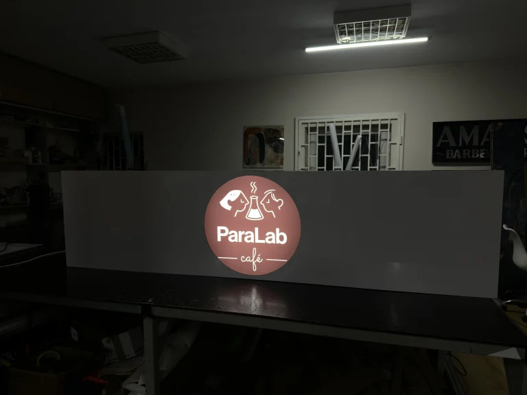 Grauer gefräster Dibond-Leuchtkasten mit beleuchtetem rundem Café-Logo