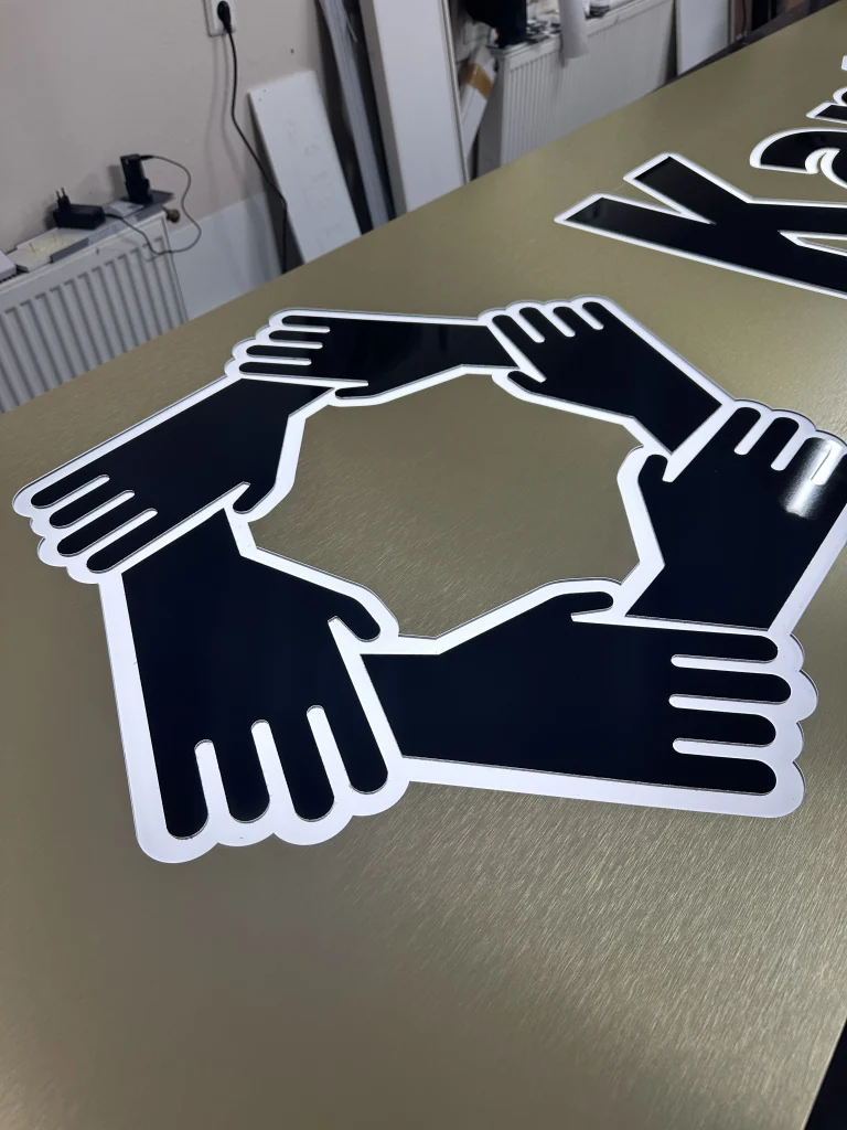 Nahaufnahme eines gefrästen Dibond-Leuchtkastens mit beleuchtetem Logo